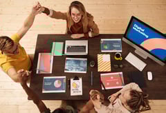 Digital marketing team celebrating success during a collaborative meeting with charts and strategy p