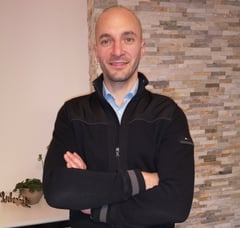 a man in a black jacket and a blue shirt