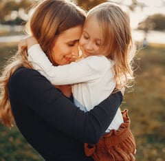 Una madre abrazando a su hija símbolo del amor incondicional de una madre