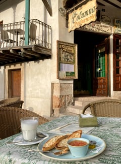 a table with a plate of food and a cup of coffee