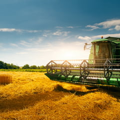 a green and yellow combiner in a field