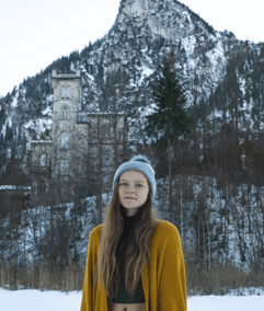 Girl standing in front of a castle in Oberammergau, Germany in the winter