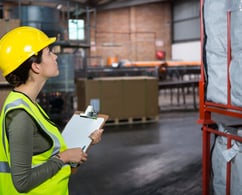 a woman in a yellow safety vest and a clipboard