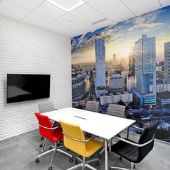 sala de reuniones con grafico en la pared y ladrillo visto pintado en blanco