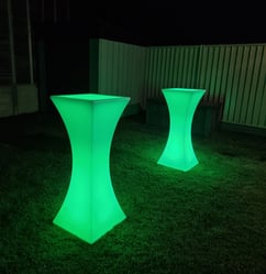 Green glowing cocktail tables in the back yard of an event in Redlands.