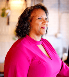Pastor Dezi Epps Berry in pink dress and smiling brightly