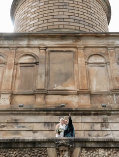 a bride and groom standing on a balcony
