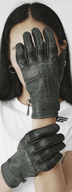 a woman wearing a white shirt and black gloves