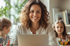 Mujer sonriente trabaja en laptop acompañada de niños, representa emprendimiento desde casa, mujer, hijo, equilibrio familiar