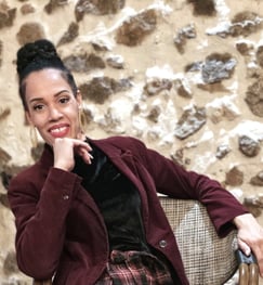 a woman in a red jacket and plaid skirt