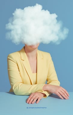 White woman in a yellow suit with arms crossed on a blue table, face hidden behind a speech balloon