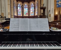 Photo of a grand piano in a chapel