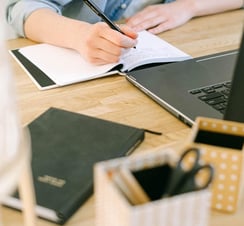 woman-writing-guest-post-on-the-notebook-about-digital-ingredients-beemk-be-emarketing