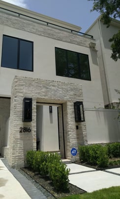 A beige brick and stucco two story home sparkling and spotless after a good window cleaning