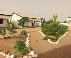 De Morgan Kunda Lodge, genesteld in een schilderachtige natuurlijke omgeving, met traditionele riete