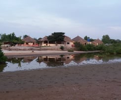 Foto van de pittoreske Tanema-kreek in Brufut, omgeven door lush groen en rustige wateren, perfect v