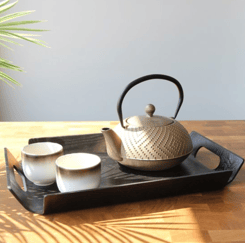 a teapot with teapots and cups on a tray