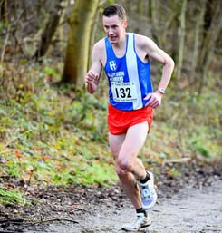a man running on a trail in the woods