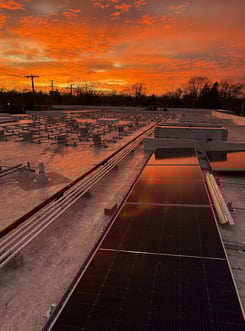 partially installed solar panels backed by sunset