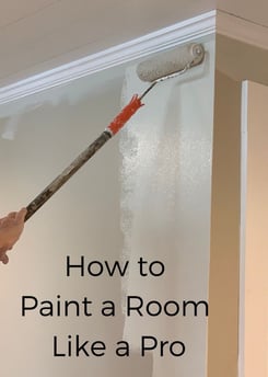a person painting a room with a paint roller