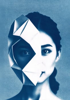 Portrait of a woman with dark hair and light skin, partially obscured by a blue geometric origami ma
