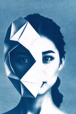 Portrait of a woman with dark hair and light skin, partially obscured by a blue geometric origami ma