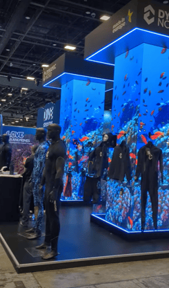 scuba dive mannequins in front of big convention columns showing a dive video