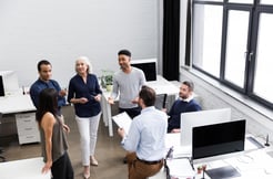 quality services, a group of people in a friendly environment standing around an office desk