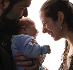 a man and woman holding a baby in a photo