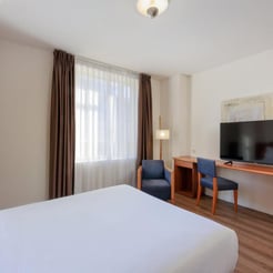 Comfortable hotel bedroom with flat-screen TV for padel camp guests