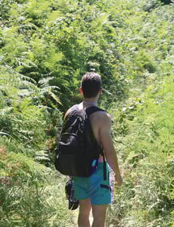 a man walking down a path with a backpack