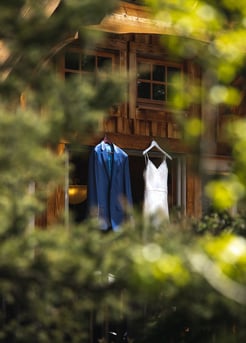 a wedding dress and suit hanging on a Cabin door in Banff