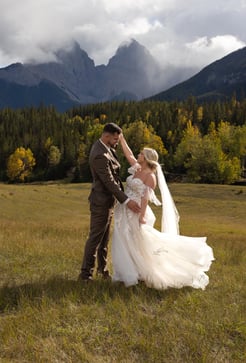 a bride and groom dancing in a field in Canmore