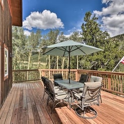 Mountain-view deck with outdoor dining and umbrella at Moose Creek Lodge.