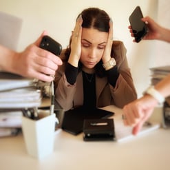 a woman sitting at a desk with her hands on her head, four hands show her watches,she seems stressed