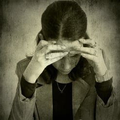 a woman with her hands on her head and hands on her head, she seems desperate and anxious