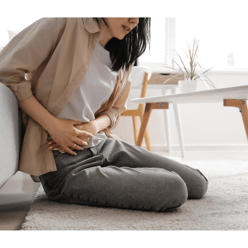 a woman sitting on a couch with her stomach