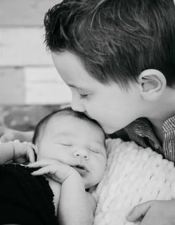 rand frère embrassant bébé sur le front – photo noir et blanc, naissance Gard