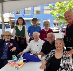 8 telelaget members sit outside under an awning