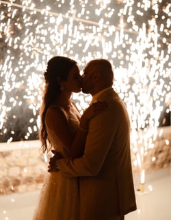 Magical stage fountain fireworks lighting up a Santorini wedding under the stars.