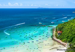 a beach with boats and people on the water