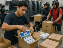 Imprenta en Lima preparando calendarios personalizados 2026 para entrega urgente, con personal embalando cajas y ambiente de