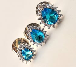 a pair of earrings with blue topaze and diamonds