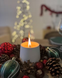 Une bougie authentique, en plâtre blanc en combustion avec des décorations de noël 