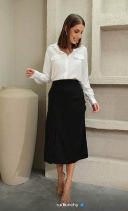 a woman in a white shirt and black skirt
