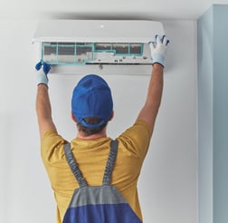 a man in overalls and a blue hat is holding a remote control unit