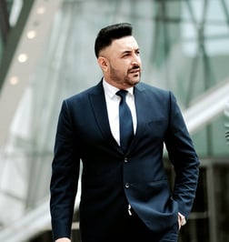 a man in a suit and tie walking down a sidewalk