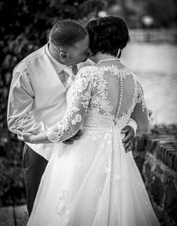 a bride and groom kissing in a black and white photo