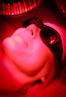 Woman having red LED light therapy of face, anti-aging therapy, skin rejuvenation