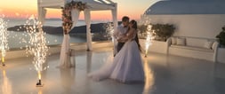 Romantic stage fireworks illuminating the couple’s first dance at a stunning Santorini wedding.